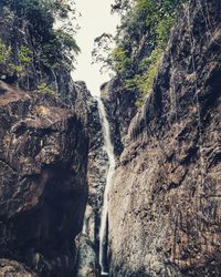 Low angle view of waterfall against sky