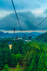 Overhead cable car over mountains against sky