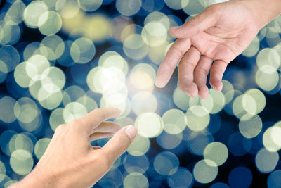 Close-up of hand on illuminated light