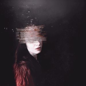 Portrait of young woman against black background