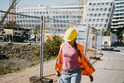 Rear view of woman standing in front of building