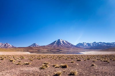 Scenic view of mountains against clear blue sky