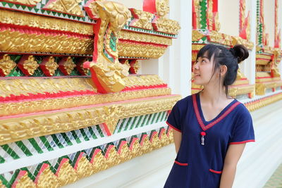 Young woman standing in corridor of temple