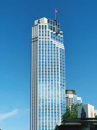 Low angle view of modern buildings against blue sky