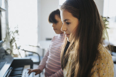 Sisters bonding over playing piano together