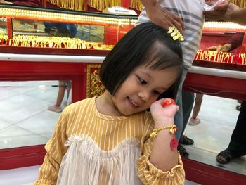 Portrait of cute girl in traditional clothing gold bracelet pay