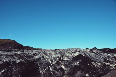 Scenic view of mountains against clear blue sky