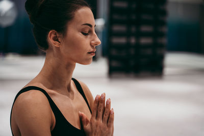 Close-up of woman meditating at gym