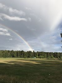 Scenic view of rainbow over landscape against sky