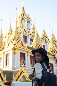 Portrait of woman by temple against building