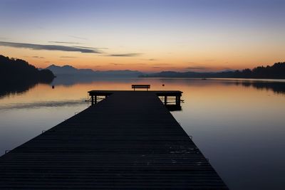 Pier over lake against sky during sunset