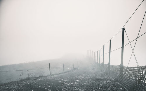 Fence against sky during foggy weather