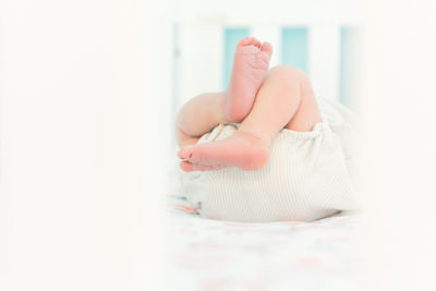 Low section of baby feet in crib