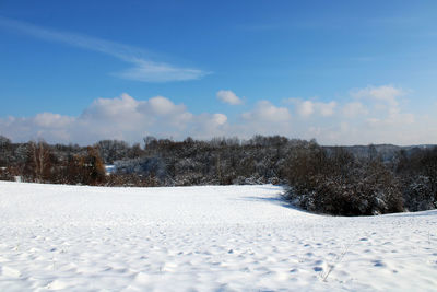 Scenic view of snow covered field against sky