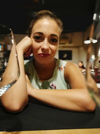 Portrait of smiling young woman sitting in restaurant