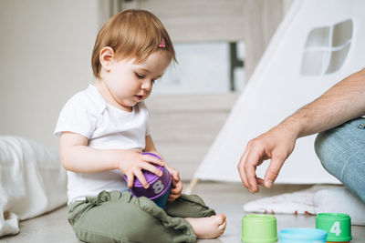 Happy father and baby girl little daughter having fun playing with toy in children room at home