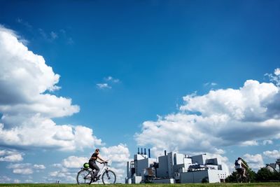 Man riding bicycle against blue sky