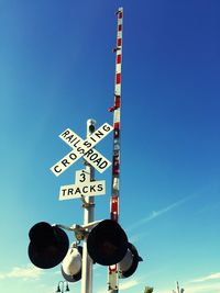 Low angle view of railway signal against blue sky