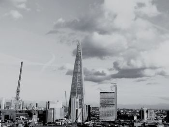 Modern buildings in city against cloudy sky