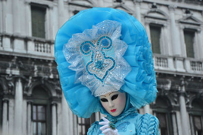 Close-up of man wearing mask against built structure