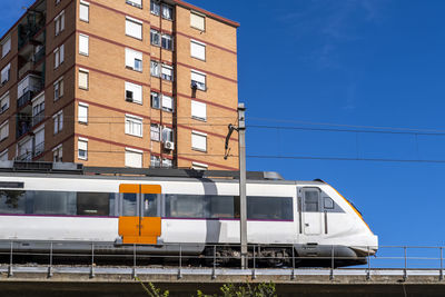 Commuter train on an elevated bridge in an apartment area in the city of hospitalet de llobregat  