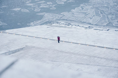 High angle view of man standing on snow covered field