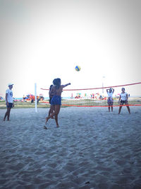 People playing with ball against the sky