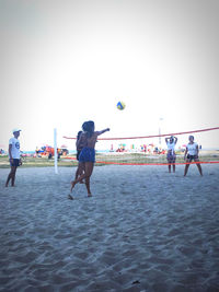 People playing with ball against the sky