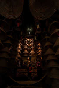 Low angle view of illuminated lighting equipment hanging at night