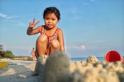 Portrait of cute boy on beach against sky