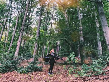 Full length of woman amidst trees in forest