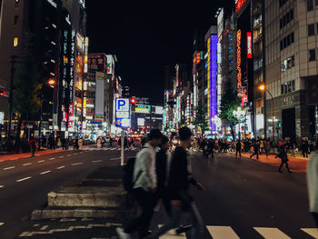 People walking on road in city at night