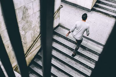 Rear view of man moving up on staircase