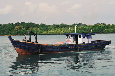 Boat moored in sea against sky