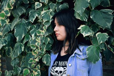 Beautiful woman standing against leaves