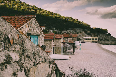 Houses on shore by buildings against sky