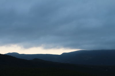 Silhouette of mountains against cloudy sky