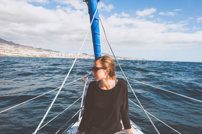 Young woman sitting in boat on sea