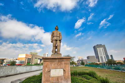 Statue against blue sky in city