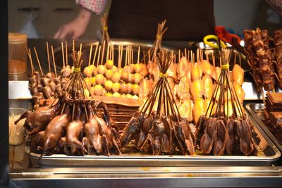 Person preparing food on display at market stall