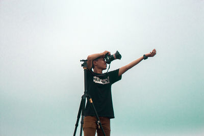 Full length of man photographing against white background