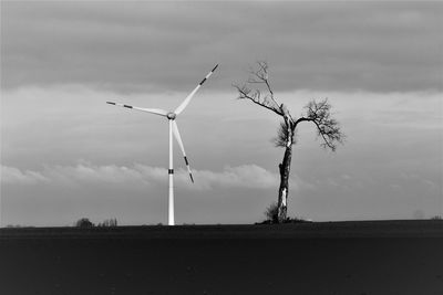 Windmill on field against sky