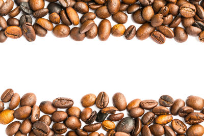 High angle view of coffee beans against white background