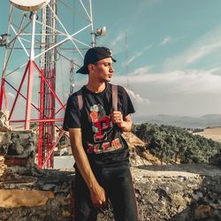 Young man looking at camera against sky