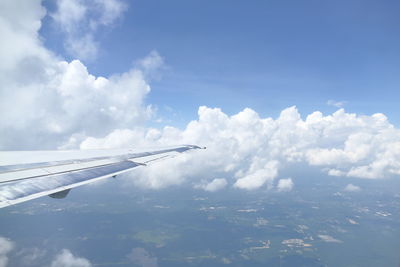 Airplane flying over clouds in sky