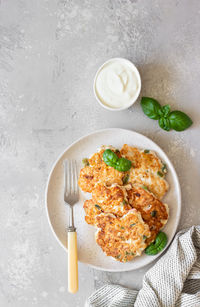 Juicy homemade chicken cutlets on a ceramic plate with basil and sour cream. 