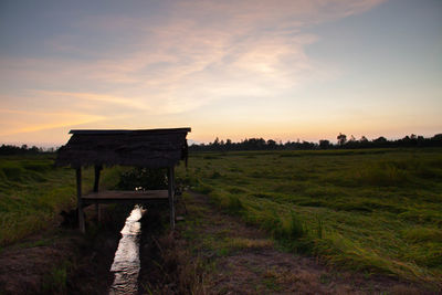 Built structure on field against sky during sunset