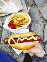 Close-up of hand holding sausage in bread