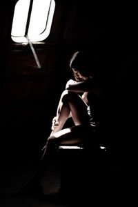 Woman sitting in the dark room