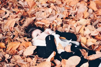 Woman lying down on autumn leaves